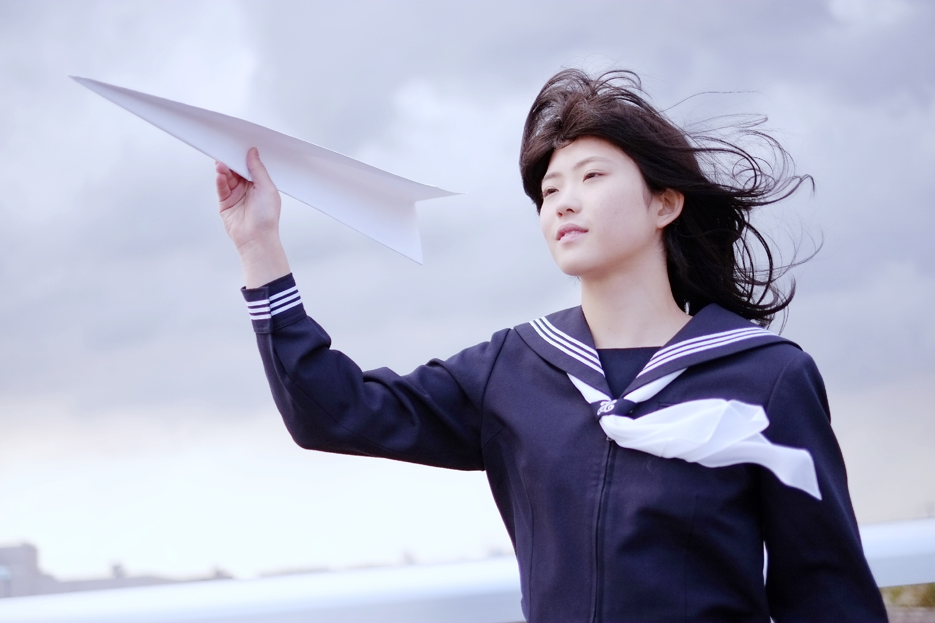 紙飛行機を飛ばす女子高生